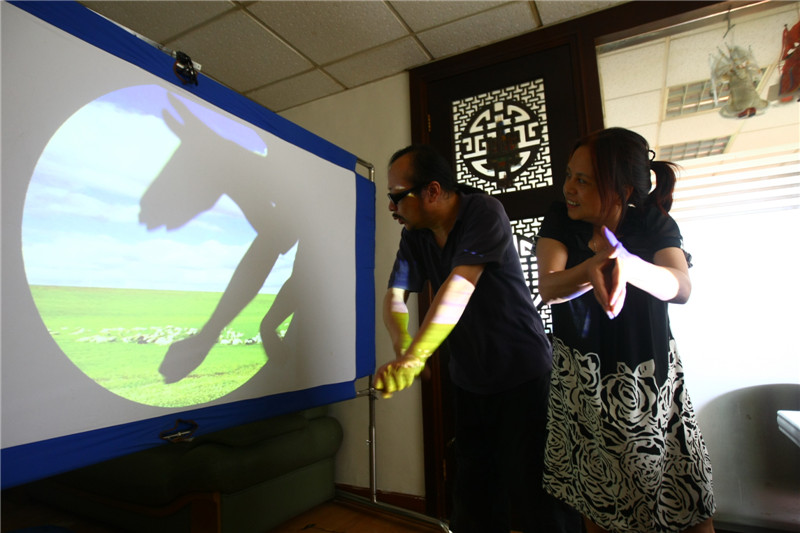 Shen Xiao en un espectáculo de sombras con manos en su estudio en Chengdu, provincia de Sichuan, el 20 de septiembre de 2014. 