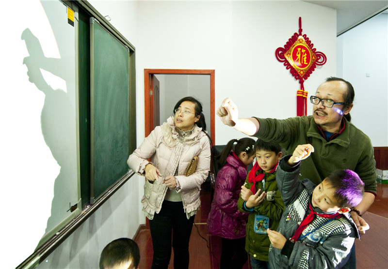 Shen Xiao en un espectáculo de sombras con manos en su estudio en Chengdu, provincia de Sichuan, el 20 de septiembre de 2014. 