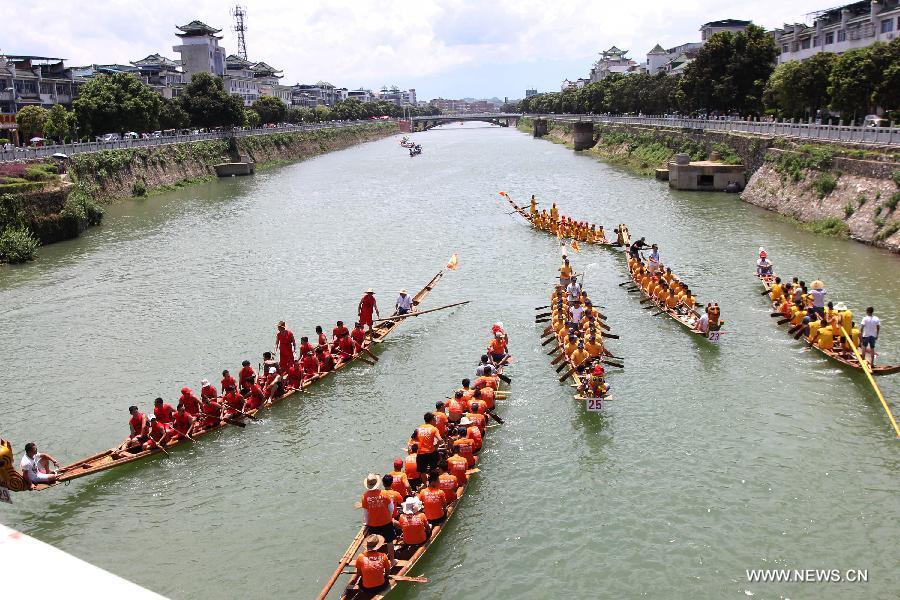 Los competidores reman en los barcos de dragón durante una carrera celebrada en el río Xiaoshuihe para celebrar el Festival del Barco de Dragón en Yongzhou, provincia de Hunan, el 16 de junio de 2015. [Foto/Xinhua]