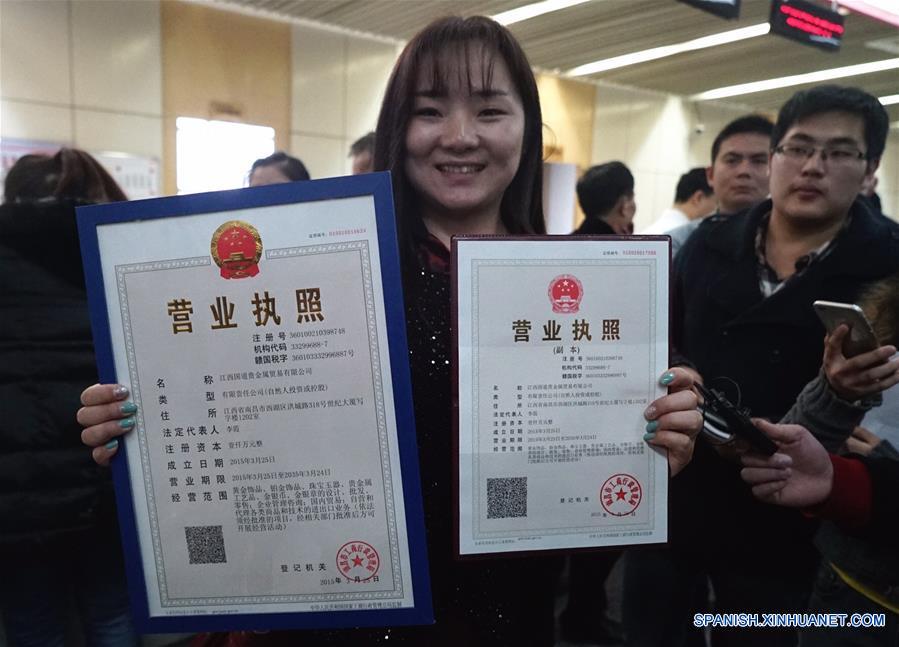 La foto tomada el pasado 26 de marzo del a?o 2015 muestra a Li Xia, representante legal de una empresa de la provinica de Jiangxi mostrando su licencia de negocio y la copia que acababa de obtener. China ha reducido los trámites burocráticos y el tiempo necesario para obtener una aprobación. 