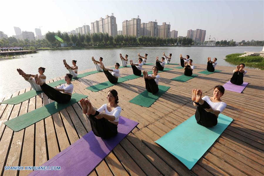 Henan: Personas practican yoga en el Parque Lago Longquan en Jiaozuo