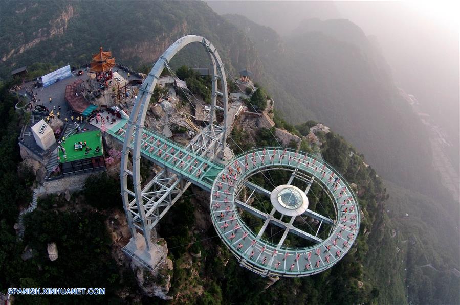 Personas practican yoga en una plataforma de cristal en Beijing