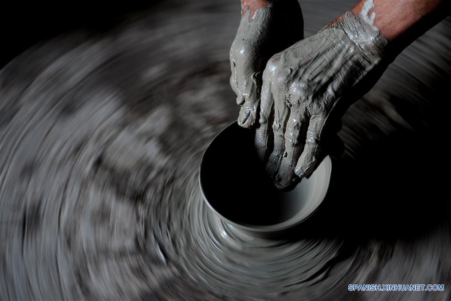 Imagen del 28 de junio de 2016 de un artesano elaborando un producto de porcelana, en la zona turística de Yaotou Kiln en el municipio de Yaotou del condado de Chengcheng, provincia de Shaanxi, en el noroeste de China. El sitio de antiguos hornos populares, cubriendo un área de cuatro kilómetros cuadrados, tiene una historia de elaboración de productos de cerámica de más de mil a?os. La técnica de elaboración de cerámica en Yaotou Kiln fue incluida en el Patrimonio Nacional Cultural Intangible en el 2006. (Xinhua/Tao Ming)