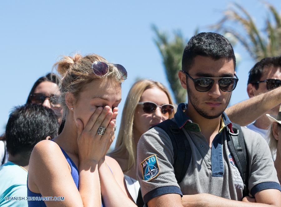 NIZA, julio 15, 2016 (Xinhua) -- Personas reaccionan frente a una ofrenda en memoria de las víctimas del ataque de un camión que embistió contra la multitud durante las celebraciones de la toma de la Bastilla en la ciudad de Niza, Francia, el 15 de julio de 2016. El fiscal de la república francesa, Francois Molins, anunció el viernes en conferencia de prensa que 84 personas murieron, incluyendo a 10 ni?os y adolescentes, durante el ataque terrorista del jueves por la noche en Niza. Un total de 202 personas resultaron lesionadas, dijo Molins, quien agregó que 52 de ellas se encuentran en estado crítico. (Xinhua/Xu Jinquan)