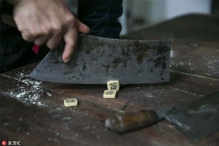 Un maestro dulcero corta la masa del Zi Dou Tang.