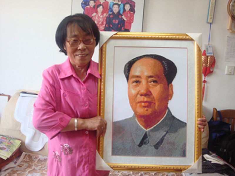 He Hong'e muestra a sus amigos un retrato de Mao Zedong que ella misma bordó en Dongying, provincia de Shandong, Ella pasó medio a?o bordando este retrato. [Foto: IC]