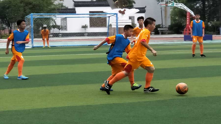 Bajo la dirección del entrenador espa?ol José y el chileno Piri juegan un partido ni?os chinos de la escuela Zhenghua en la ciudad de Kaili, suroeste de China.