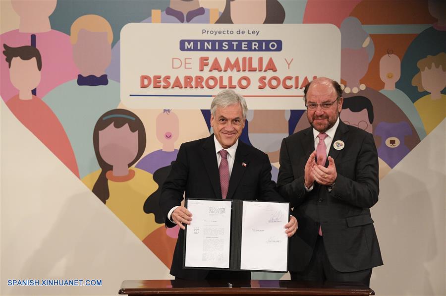 SANTIAGO, julio 26, 2018 (Xinhua) -- El presidente de Chile, Sebastián Pi?era (i), junto al ministro de Desarrollo Social de Chile, Alfredo Moreno (d), muestra el proyecto de ley para la creación del Ministerio de Familia y Desarrollo Social después de firmarlo, en el Palacio de La Moneda, en Santiago, capital de Chile, el 26 de julio de 2018. (Xinhua/Jorge Villegas)