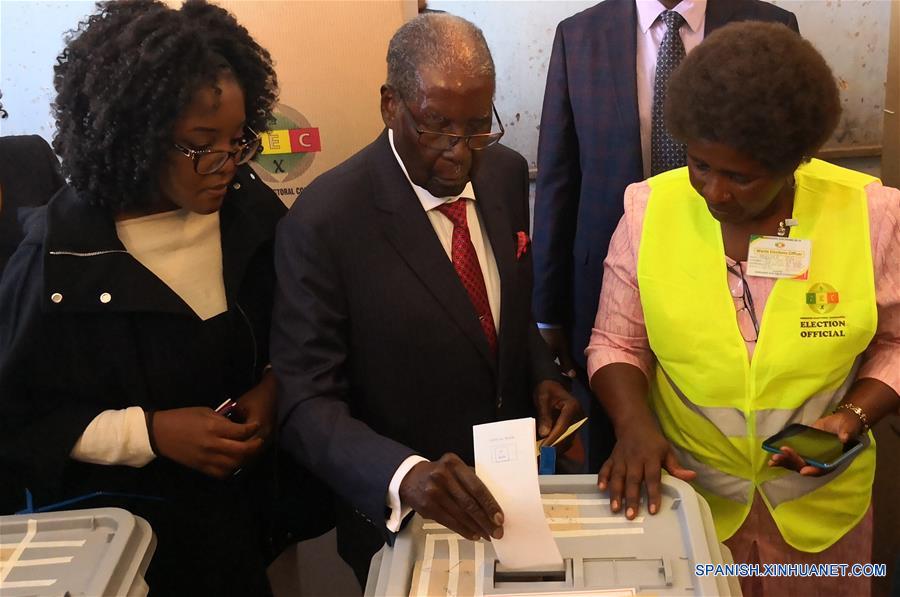 El ex presidente de Zimbabue, Robert Mugabe (c), emite su voto en Highfield, Harare, Zimbabue, el 30 de julio de 2018. Los zimbabuenses empezaron el lunes a ejercer su derecho al sufragio en las primeras elecciones presidenciales desde que el ex presidente Robert Mugabe renunciara a su cargo en noviembre de 2017. (Xinhua/Zhang Yuliang)