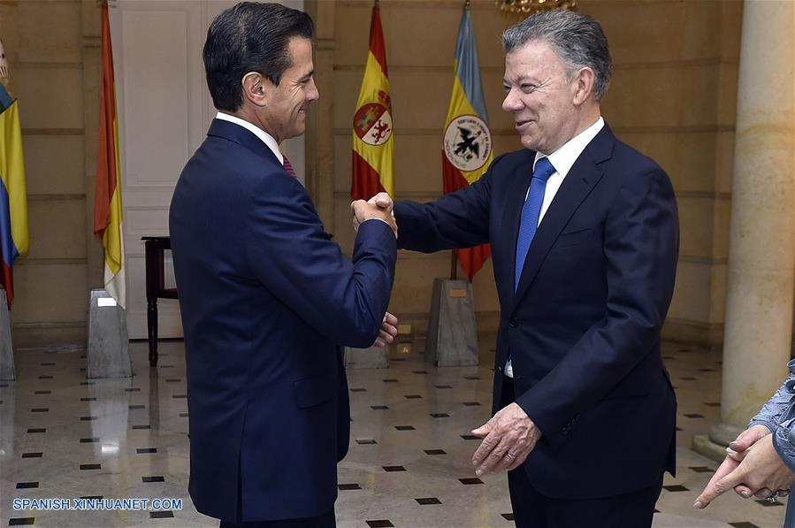 BOGOTA, agosto 6, 2018 (Xinhua) -- Imagen cedida por la Presidencia de Colombia, del presidente colombiano, Juan Manuel Santos (d), recibiendo a su homólogo de México, Enrique Pe?a Nieto (i), previo a la cena en honor a los jefes de Estado y de Gobierno que participarán en la ceremonia de posesión presidencial, en Bogotá, capital de Colombia, el 6 de agosto de 2018. De acuerdo con información de la prensa local, Santos dejará el martes la Presidencia colombiana después de ocho a?os de mandato, e Iván Duque tomará posesión del cargo. (Xinhua/Efraín Herrera/Presidencia de Colombia)
