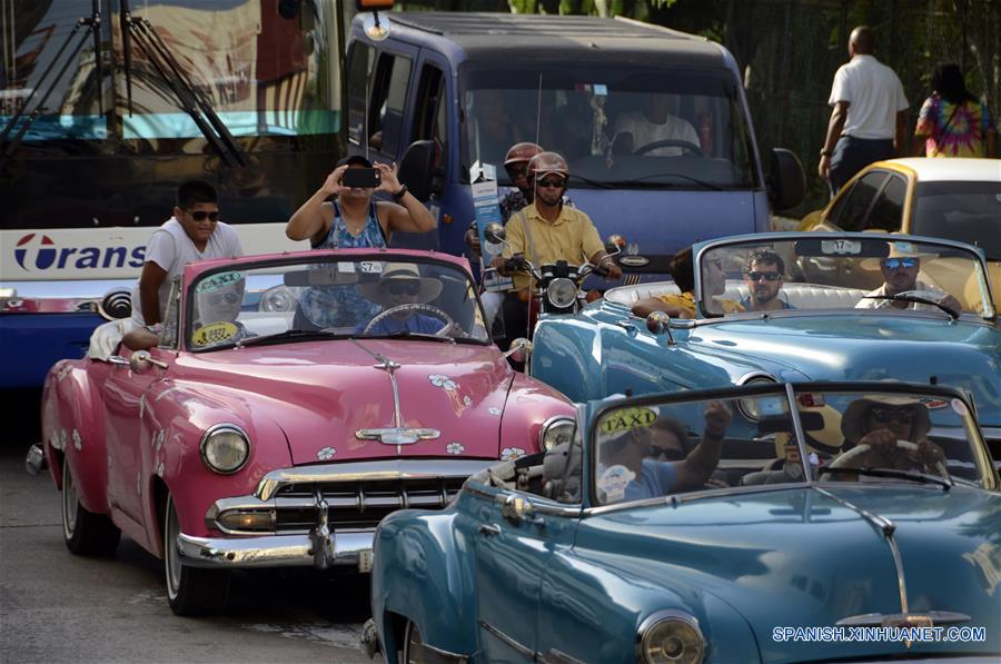 Imagen del 10 de agosto de 2018 de turistas extranjeros tomando fotografías a bordo de un auto clásico de los a?os 50 que transita a través de una avenida en la localidad del Vedado del municipio Plaza de la Revolución, en La Habana, Cuba. La industria turística cubana, el sector más dinámico de la economía de la isla, se ha desacelerado en lo que va del a?o como resultado de las medidas restrictivas de la administración del presidente estadounidense Donald Trump. Esta semana, el Ministerio de Turismo de Cuba (MINTUR) informó de la llegada de 3 millones de vacacionistas, una cifra lograda 16 días más tarde que en 2017, la cual confirmó la caída del ritmo de arribos a la isla. Desde 2012, el arribo de vacacionistas extranjeros a Cuba ha mantenido una tasa de crecimiento promedio del 13 por ciento, lo que convirtió a la llamada "Industria del ocio" en una de las principales fuentes de ingresos de la economía cubana. El a?o pasado, la isla logró la cifra histórica de 4 millones 689.000 visitantes foráneos, cifra que significó un incremento del 16,2 por ciento de turistas respecto al a?o anterior. (Xinhua/Joaquín Hernández)