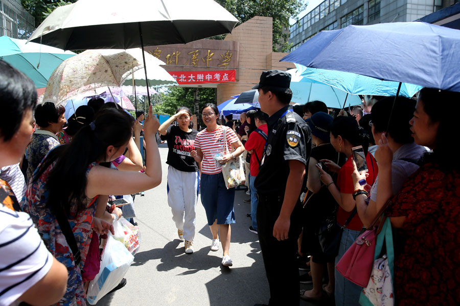 Los padres dan la bienvenida a los ni?os que han completado el examen en la Escuela afiliada de la Universidad de Pekín en Beijing. [Wang Jing / China Daily]