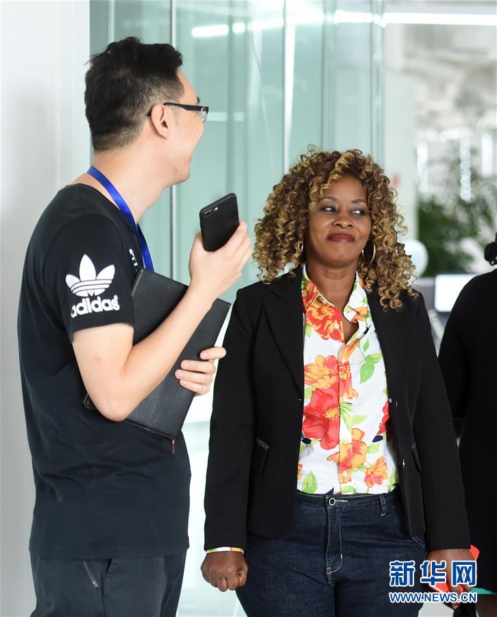 Hilde(d) charla con sus colegas tanzaniano en la sede de StarTimes Group. Yizhuang, Beijing, el 14 de agosto de 2018. (Foto: Luo Xiaoguang / Xinhua)