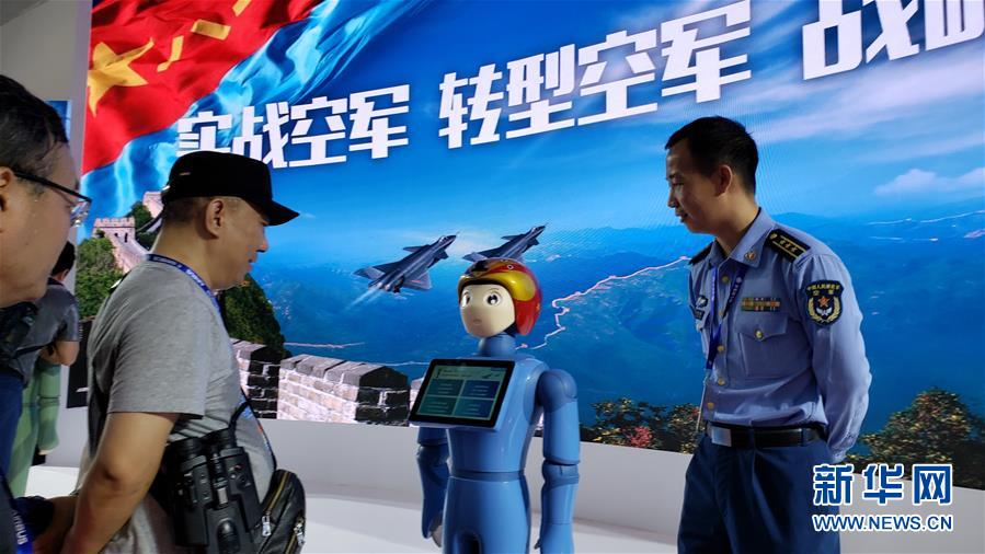 En la sala de exhibición y reclutamiento de las Fuerzas Aéreas de China, dentro del XII Salón Aeronáutico de China (China Air Show), un asistente conversa con el robot inteligente para la promoción de reclutamiento Feifei, el 7 de noviembre. Por Li Gang, Agencia de Noticias Xinhua