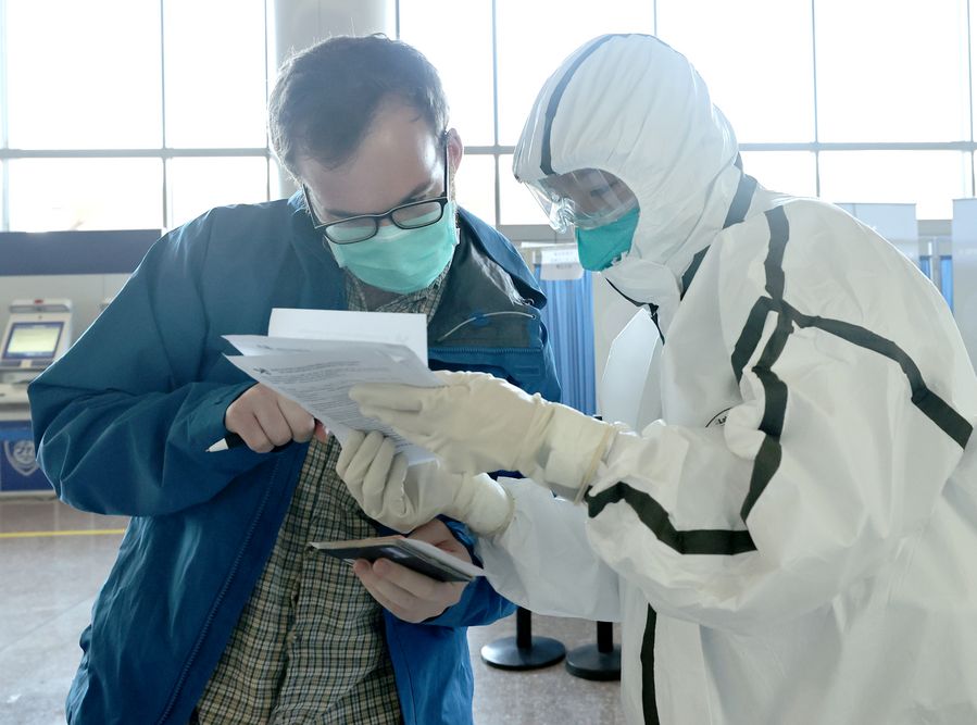 Un funcionario aduanero verifica la declaración de salud de un pasajero en el Aeropuerto Internacional Capital de Beijing, capital de China, el 7 de marzo de 2020. Las aduanas de todo el país vienen vigilando de cerca la epidemia tanto a nivel nacional como internacional. (Xinhua/Chen Jianli)