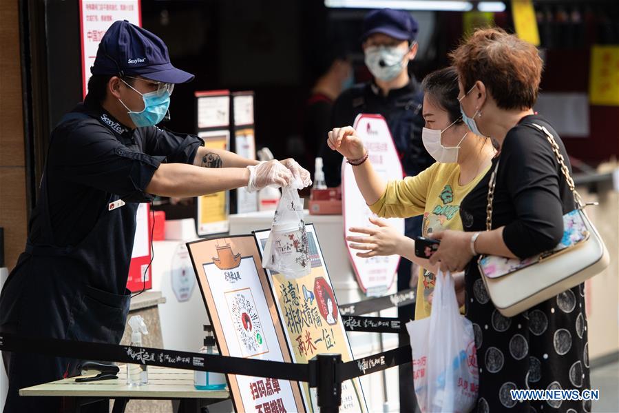La gente recoge las bebidas pedidas en línea en una tienda de Changsha, provincia de Hunan. 