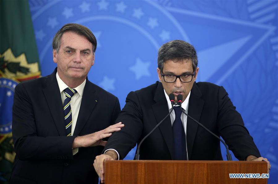 BRASILIA, 27 marzo, 2020 (Xinhua) -- El presidente de Brasil, Jair Bolsonaro (i), y el presidente del Banco Central brasile?o, Roberto Campos Neto (d), asisten a una conferencia de prensa para anunciar las medidas económicas para combatir la enfermedad provocada por el nuevo coronavirus (COVID-19), en el Palacio de Planalto, en Brasilia, Brasil, el 27 de marzo de 2020. El gobierno de Brasil anunció el viernes un programa de auxilio a peque?as y medianas empresas con líneas de financiamiento para el pago de salarios y mantener así el empleo en el sector. El programa ayudará a los ingresos de un porcentaje importante de la fuerza de trabajo durante la fase crítica por la epidemia del nuevo coronavirus. (Xinhua/Lucio Tavora)