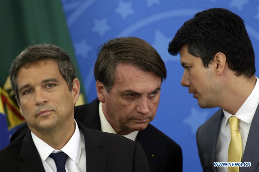 BRASILIA, 27 marzo, 2020 (Xinhua) -- El presidente brasile?o, Jair Bolsonaro (c), el presidente del Banco Nacional de Desarrollo Económico y Social de Brasil, Gustavo Montezano (d), y el presidente del Banco Central brasile?o, Roberto Campos Neto (i), asisten a una conferencia de prensa para anunciar las medidas económicas para combatir la enfermedad provocada por el nuevo coronavirus (COVID-19), en el Palacio de Planalto, en Brasilia, Brasil, el 27 de marzo de 2020. El gobierno de Brasil anunció el viernes un programa de auxilio a peque?as y medianas empresas con líneas de financiamiento para el pago de salarios y mantener así el empleo en el sector. El programa ayudará a los ingresos de un porcentaje importante de la fuerza de trabajo durante la fase crítica por la epidemia del nuevo coronavirus. (Xinhua/Lucio Tavora)