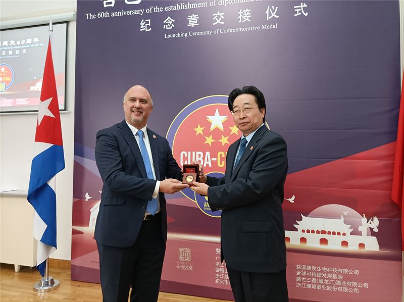 Wang Hua, subsecretario de la Fundación China para la Paz y el Desarrollo, entrega a Carlos Miguel Pereira, embajador de Cuba en China, la medalla conmemorativa por el 60 aniversario del establecimiento de relaciones diplomáticas entre China y Cuba, 25 de septiembre del 2020. (Foto: Pueblo en Línea)