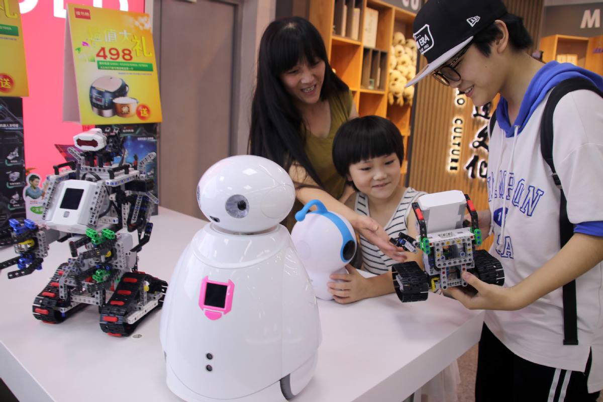 Una familia elige un robot educativo en una librería en Suzhou, provincia de Jiangsu, este de China. [Foto de Wang Jiankang / China Daily]