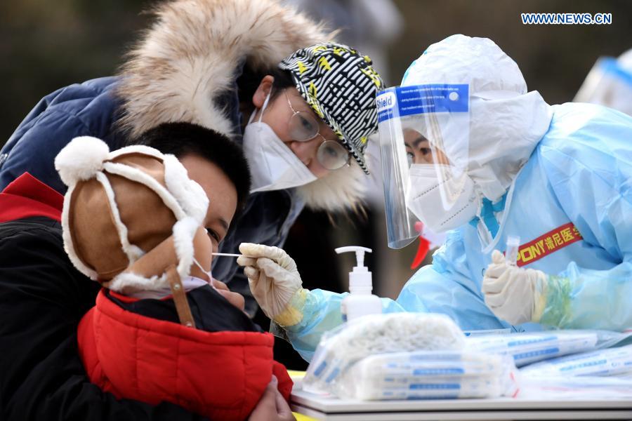 Un trabajador de la salud recoge muestras de hisopo de un residente en un sitio de pruebas en una comunidad del distrito Yuhua, Shijiazhuang, capital de Hebei, 10 de enero del 2021. La segunda ronda de las pruebas de ácido nucleico ha comenzado en algunas comunidades de Shijiazhuang. [Foto: Xinhua]