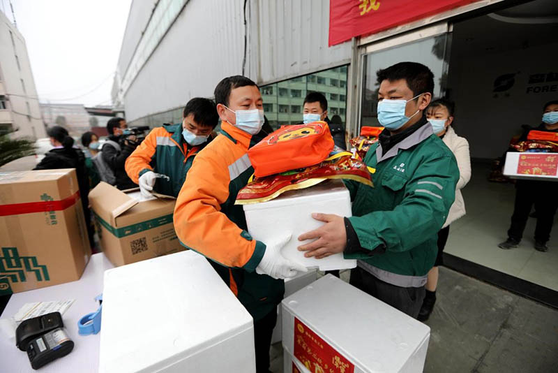 Los mensajeros de China Post entregan productos a los empleados en Wenling, provincia de Zhejiang, en el este de China, que decidieron no regresar a casa para el Festival de Primavera debido a la pandemia de COVID-19, el 20 de enero (Pueblo en Línea / Yang Peng)
