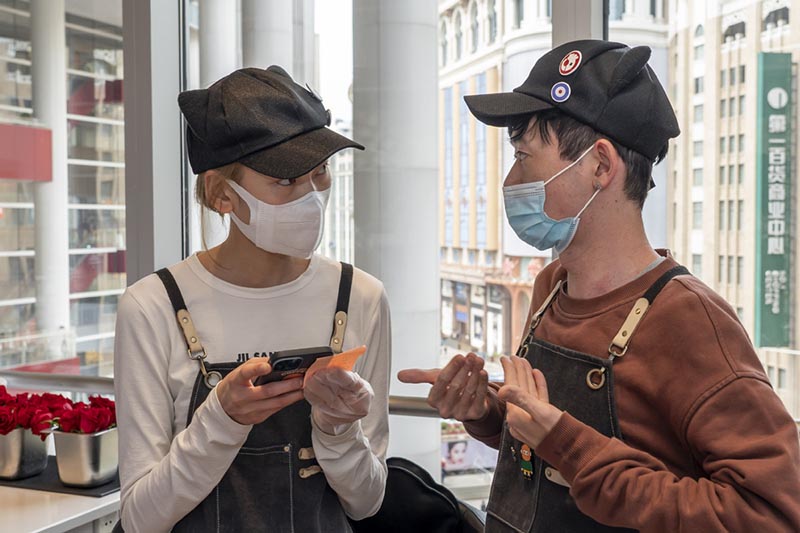 A Ken se comunica con un colega mediante lenguaje de se?as. [Foto: Xinhua]