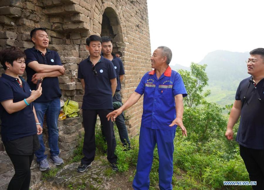 Zhang Heshan (segundo a la derecha) presenta la cultura de la Gran Muralla a los turistas en la Gran Muralla de Chengziyu en Qinhuangdao, provincia de Hebei, 7 de julio del 2021. (Foto: Xinhua/ Jin Haoyuan)