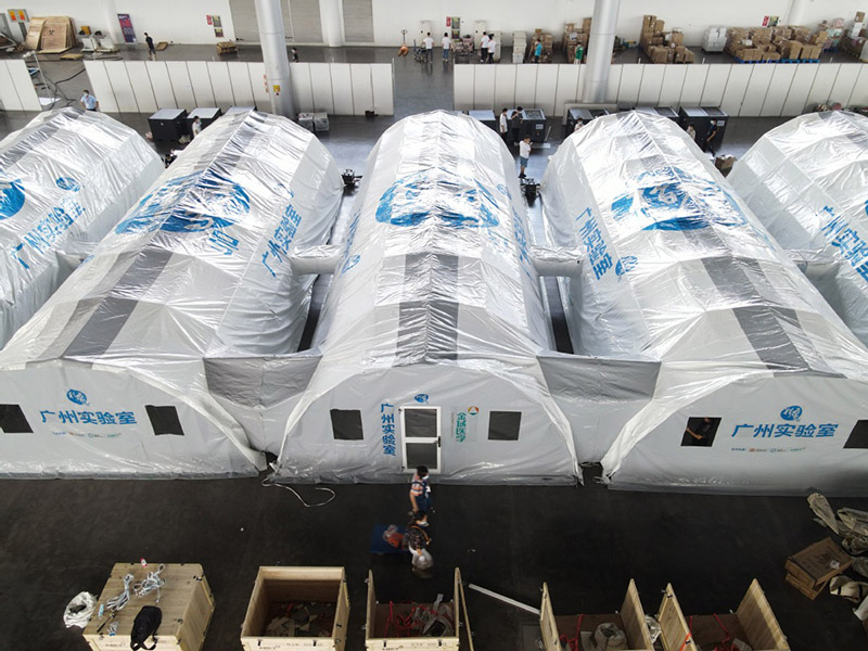 Los miembros del personal instalan un laboratorio de pruebas inflable "Falcon" para las pruebas de ácido nucleico de COVID-19 en el Centro Internacional de Exposiciones de Yangzhou, provincia de Jiangsu, en el este de China, el 10 de agosto de 2021. [Foto de Meng Delong / para China Daily]