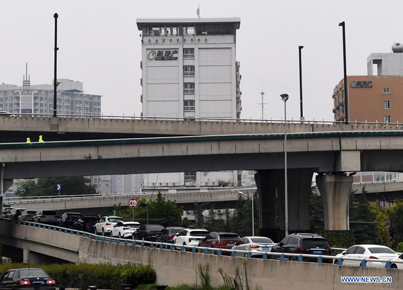 Personas estacionan vehículos en la calle Jinshui de Zhengzhou, capital de la provincia de Henan, en el centro de China, el 22 de agosto de 2021. (Xinhua / Zhang Haoran)