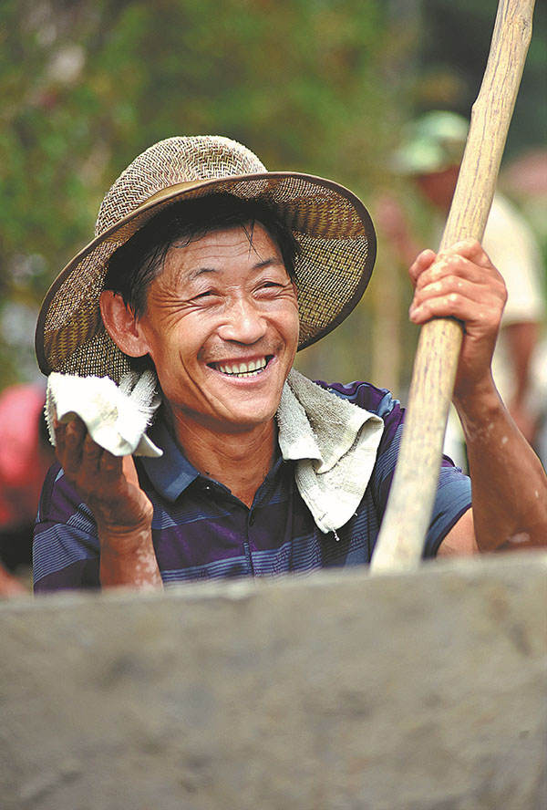 Feng se toma un descanso mientras trabaja en un sitio de construcción el 10 de agosto. [Foto de Zhao Dongshan y Fu Youmin / Para China Daily]