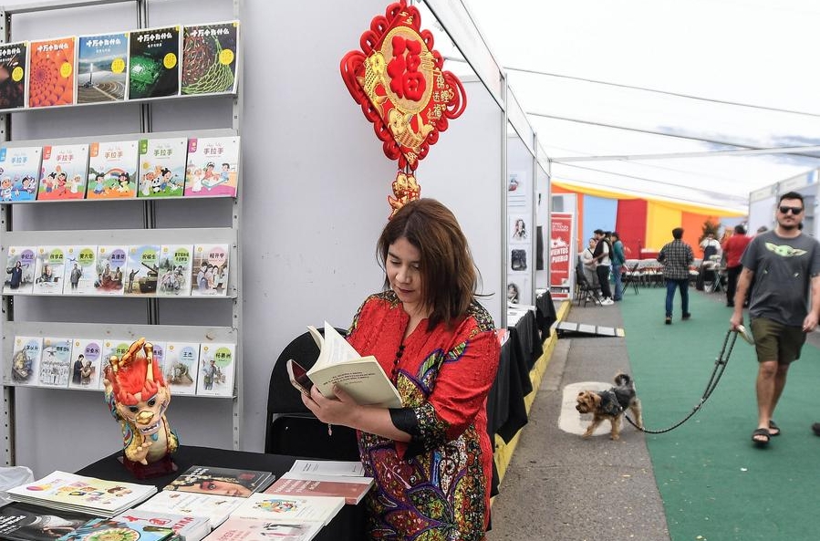 Imagen del 5 de abril de 2025 de una mujer leyendo un libro en un estand durante la Feria Internacional del Libro de Ciencias Sociales (FILCS), en la municipalidad de Recoleta, en Santiago, capital de Chile. La sexta FILCS fue inaugurada el sábado en Santiago de Chile con China como país invitado. (Xinhua/Jorge Villegas) 