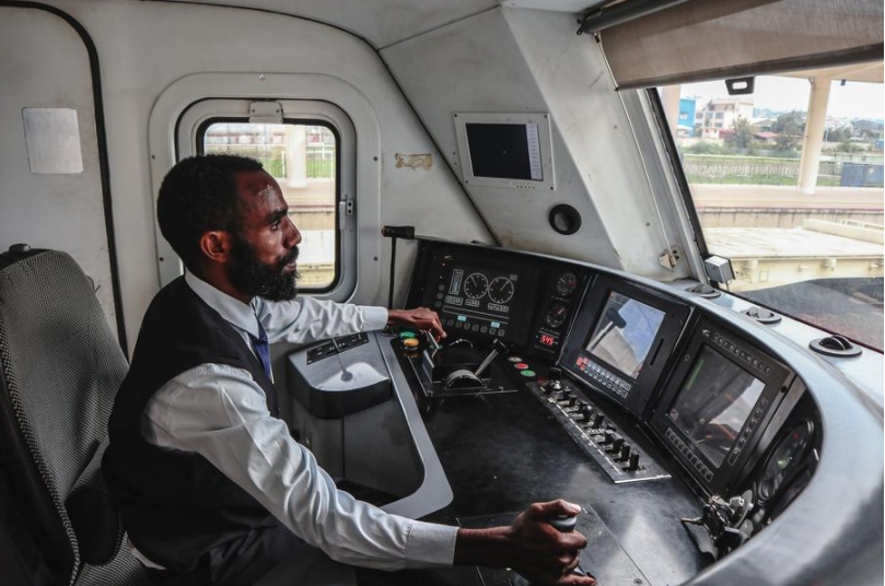 Imagen del 10 de mayo de 2024 de un conductor de locomotora etíope, entrenado por la contraparte china, controlando el tren en la cabina, en Etiopía. (Xinhua/Liu Fangqiang) 