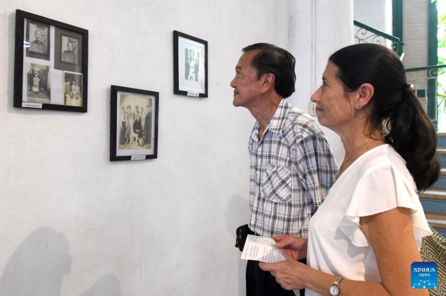  Personas observan fotografías durante la exposición "Raíces en el Caribe. Familias sino-cubanas: tradición y fusión", en la Casa de las Artes y Tradiciones Chinas, en el Barrio Chino de La Habana, capital de Cuba, el 11 de junio de 2025. El Barrio Chino de La Habana recordó con la apertura de una exposición fotográfica la llegada a Cuba hace 178 a?os de los primeros culíes, quienes dejaron una profunda huella en la historia y en la formación de la nacionalidad cubana. (Xinhua/Joaquín Hernández)