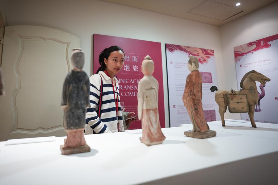 Imagen del 22 de mayo de 2025 de una mujer observando una obra durante la exposición "El tiempo de los caballos y los carruajes, transportes e intercambios por la Ruta de la Seda" en la Biblioteca Museo Casa Lleras, en la ciudad de Bogotá, capital de Colombia. (Xinhua/Andrés Moreno) 