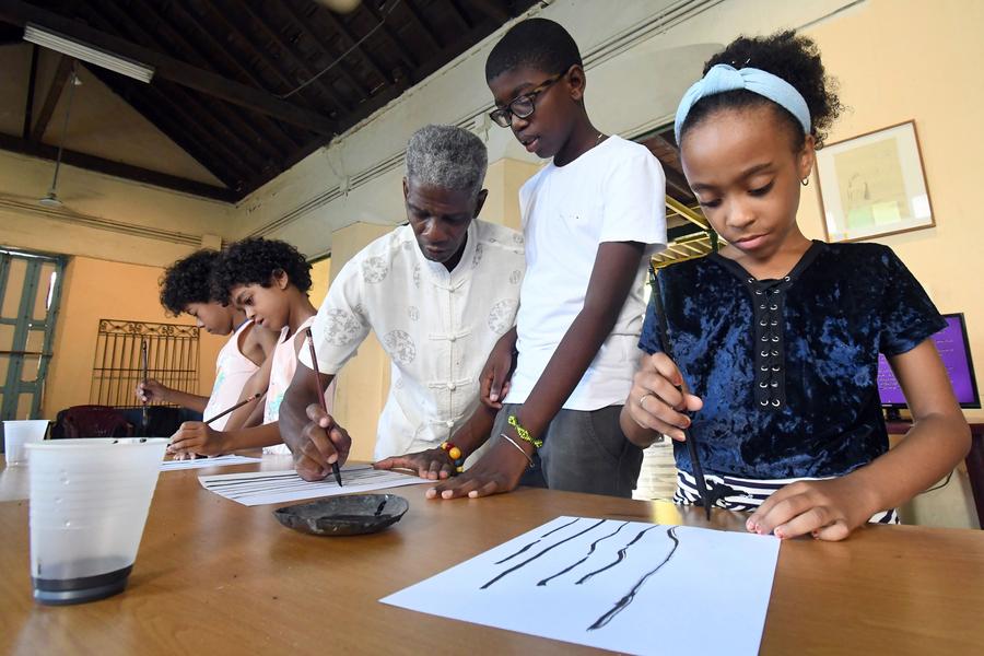 El pintor y calígrafo, Alexis González (c), imparte un curso de pintura tradicional china a un grupo de ni?os en la Casa de las Artes y Tradiciones China, en La Habana, capital de Cuba, el 28 de julio de 2025. (Xinhua/Joaquín Hernández)