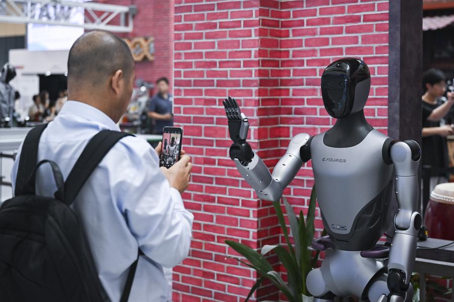 Un visitante interactúa con un robot en la Conferencia Mundial de IA 2025 en Shanghai, este de China, el 29 de julio de 2025. (Xinhua/Chen Haoming)