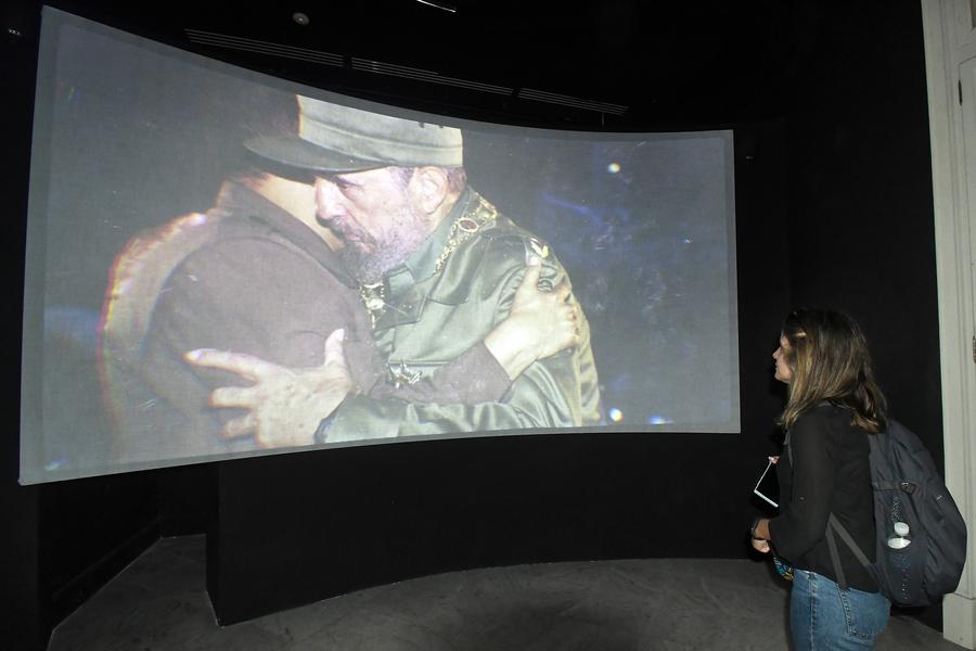 Imagen del 13 de febrero de 2024 de una mujer observando una imagen del líder histórico cubano, Fidel Castro, proyectada en el Centro Fidel Castro Ruz, en La Habana, capital de Cuba. (Xinhua/Joaquín Hernández)