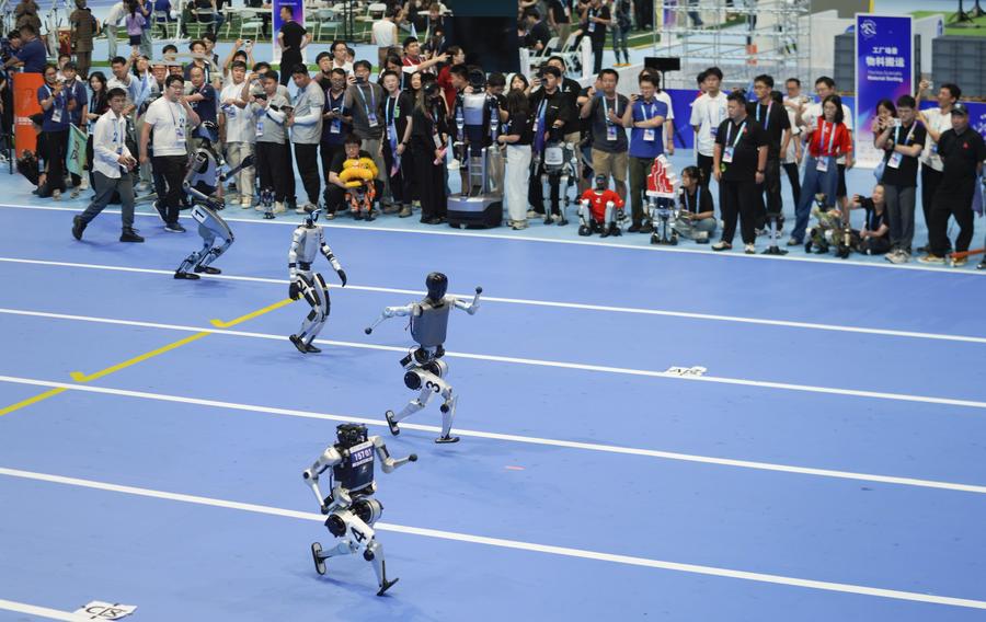 Robots humanoides compiten en una carrera de 100 metros durante la ceremonia de apertura de los Juegos Mundiales de Robots Humanoides 2025, en Beijing, la capital de China, el 14 de agosto de 2025. (Xinhua/Xie Han)
