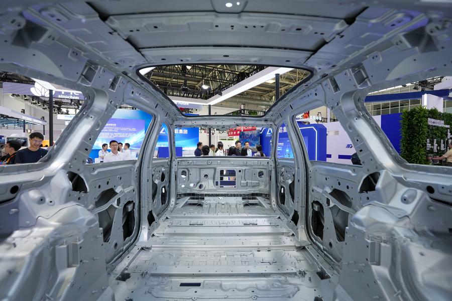 Personas observan la carrocería de un vehículo de nueva energía exhibido en el área de la Cadena de Manufactura Avanzada durante la III Exposición Internacional de la Cadena de Suministro de China (CISCE, por sus siglas en inglés), en Beijing, capital de China, el 16 de julio de 2025. (Xinhua/Ju Huanzong) 