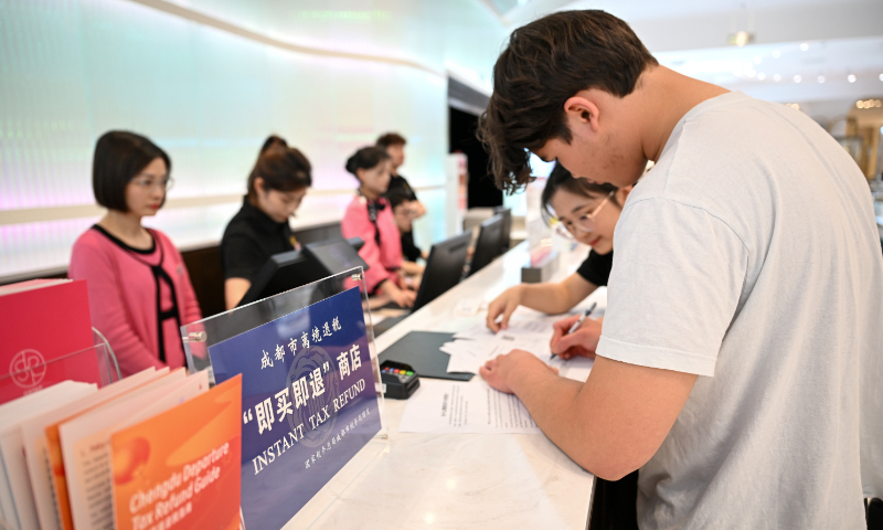 Un consumidor holandés (derecha) gestiona un trámite de devolución de impuestos en un centro comercial de Chengdu, provincia de Sichuan, suroeste de China, el 27 de abril de 2025. Foto: VCG