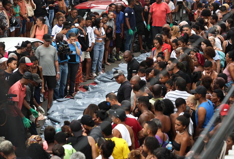 Personas observan cuerpos que yacen sobre el suelo tras la mega operación policial contra el grupo criminal "Comando Vermelho", en Río de Janeiro, Brasil, el 29 de octubre de 2025. (Xinhua/Claudia Martini) 