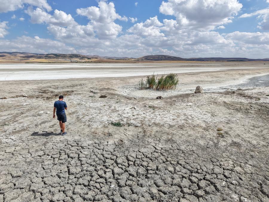 Imagen tomada con un dron el 5 de septiembre de 2025 de un hombre caminando sobre el lecho agrietado del lago Mogan en Ankara, Turquía. (Xinhua/Mustafa Kaya)