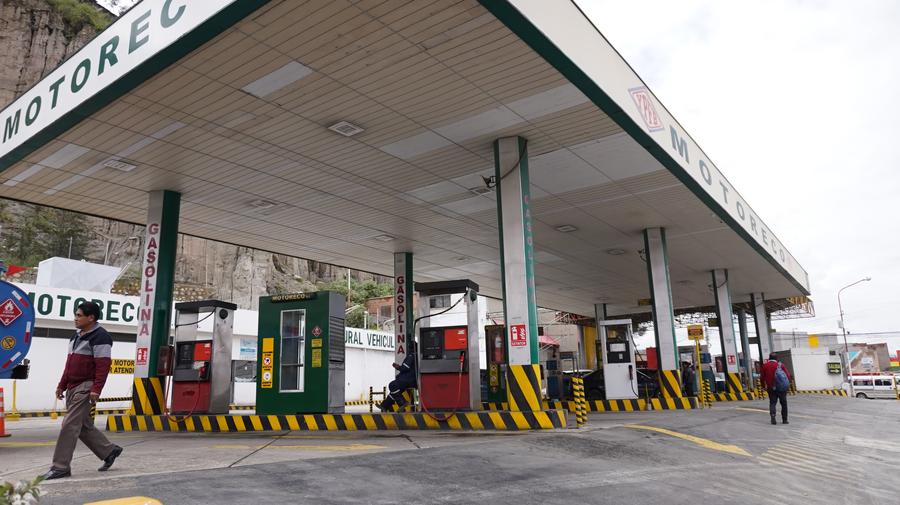 Imagen del 11 de marzo 2025 de un empleado (c) esperando la llegada de la cisterna para proveer gasolina a vehículos particulares y de transporte urbano en una estación de servicio, en la ciudad de La Paz, Bolivia. (Xinhua/Javier Mamani)